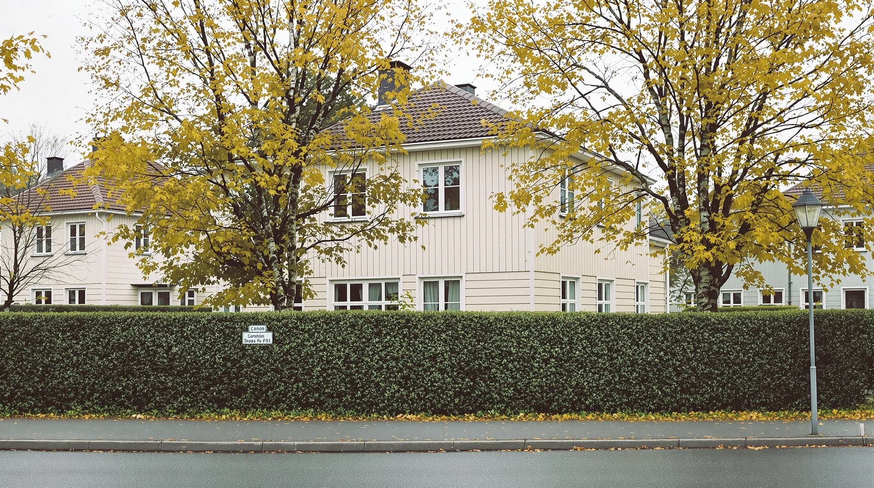 Villa med nymålad träfasad och vita fönsterfoder på en lugn villagata
